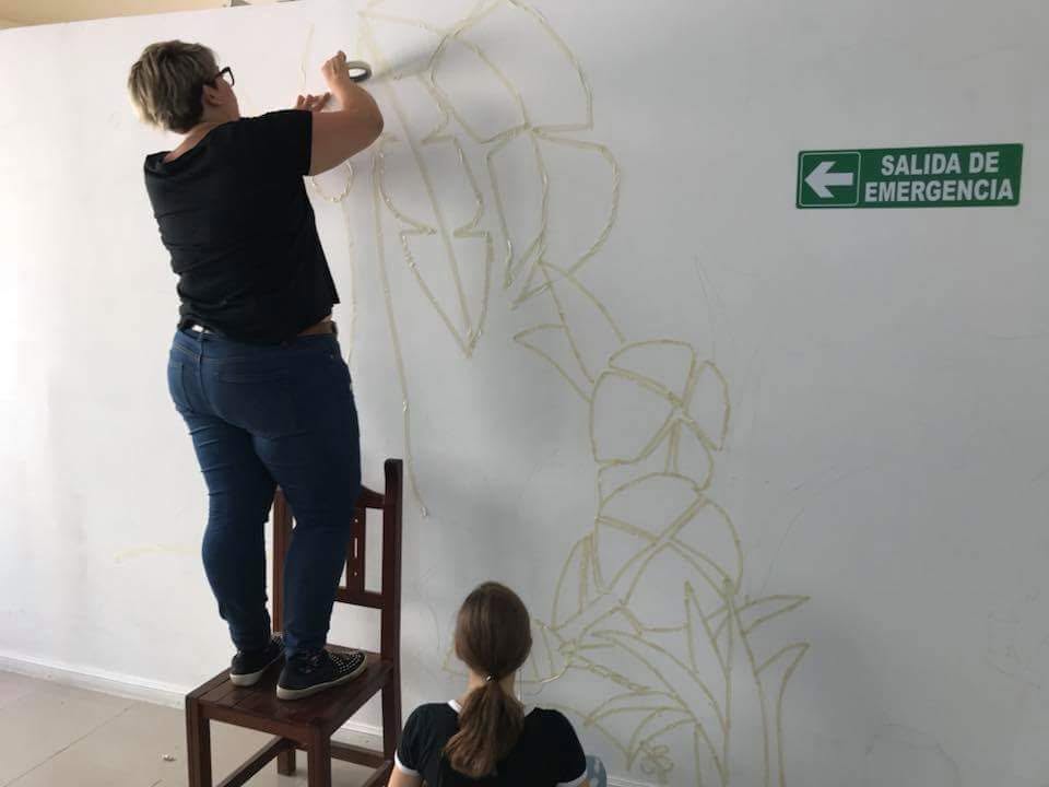 Trazado de las figuras del mural con cinta de papel sobre la pared de ITEF