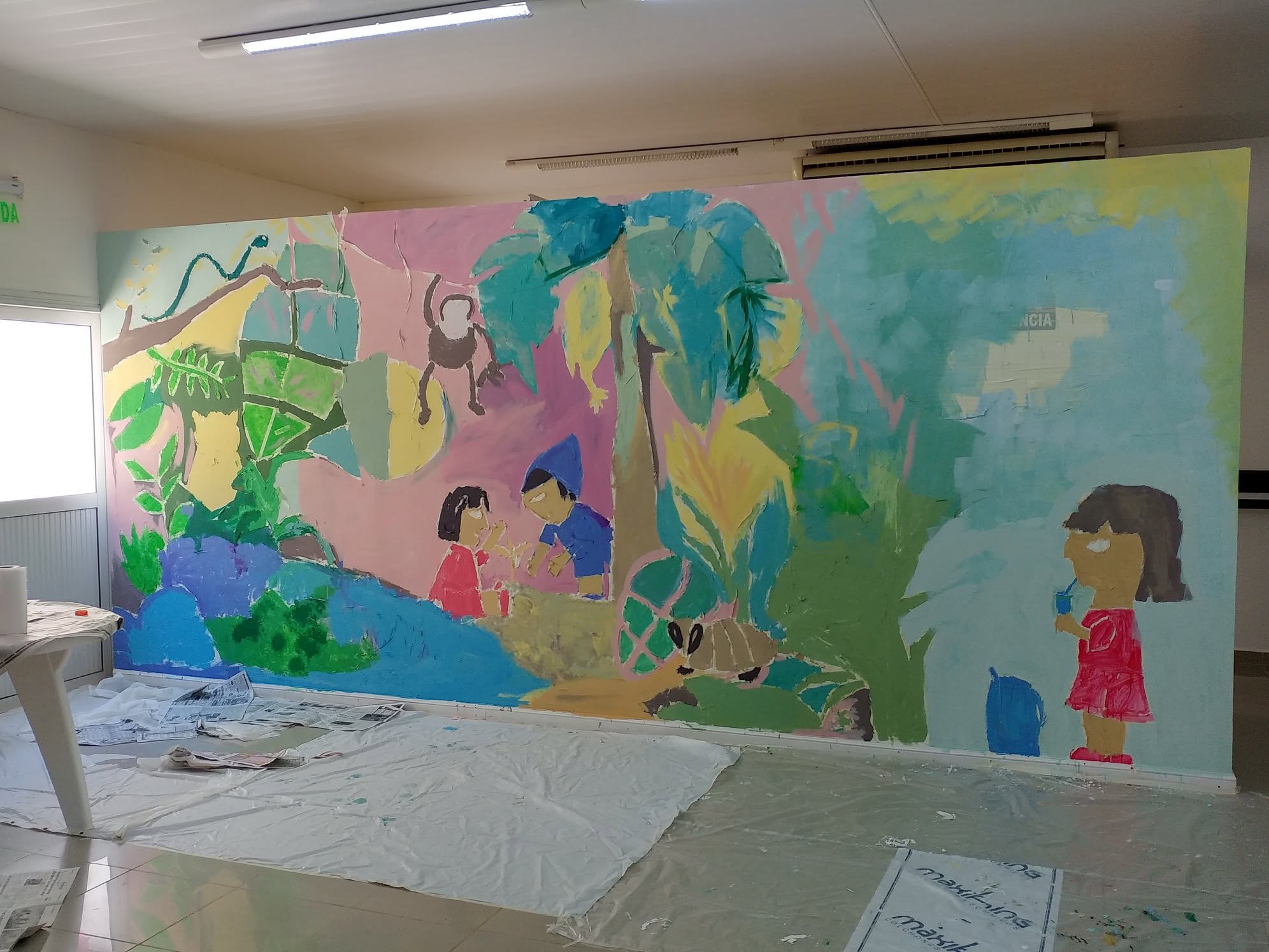 Vista del mural lleno de colores durante la intervención pictórica colectiva