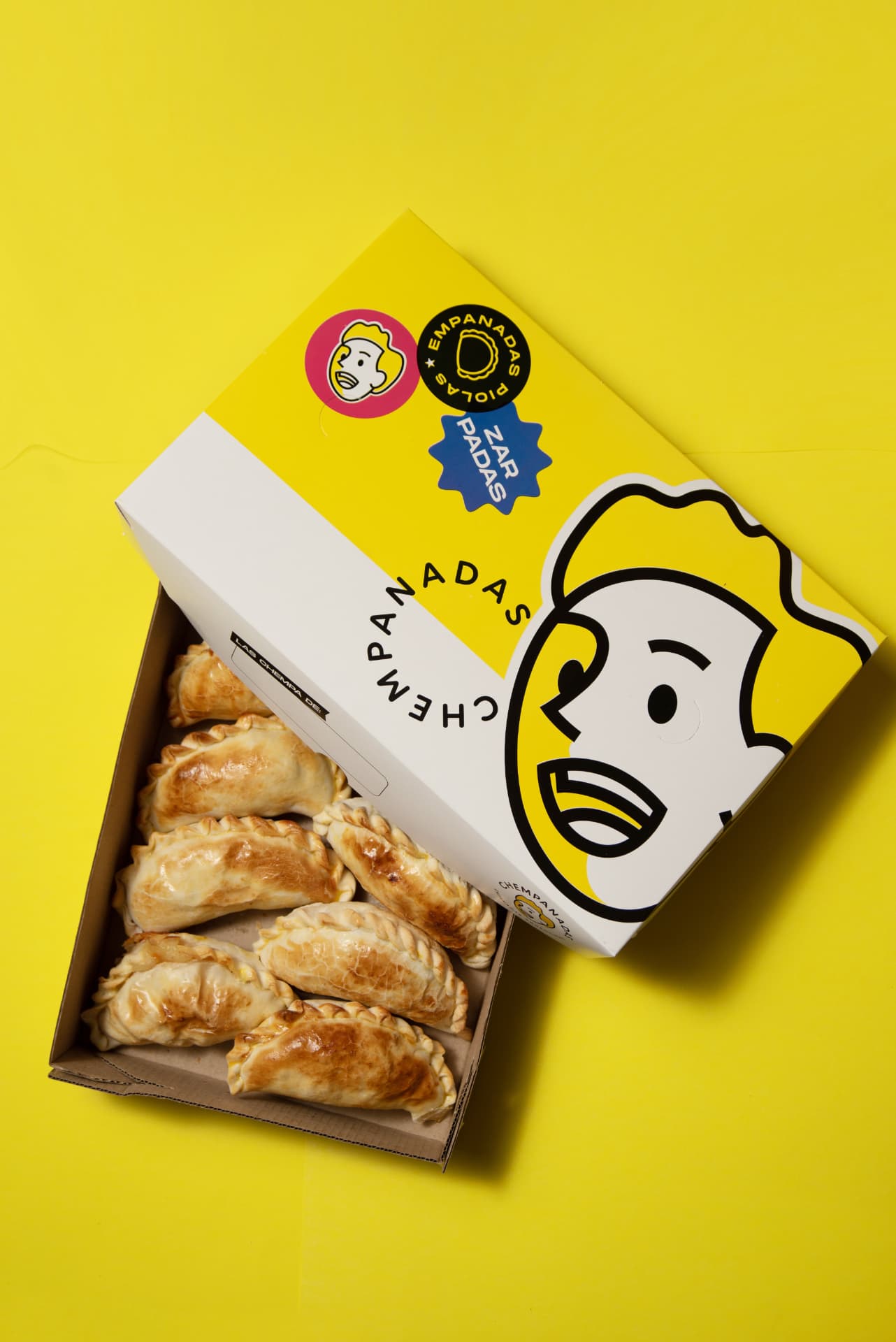 Packaging original de Chempanadas con empanadas, sobre fondo amarillo
